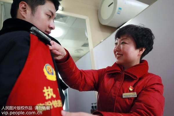 2020年1月21日，临汾西站（山西），临汾铁路公安处民警李永浩上岗前，母亲陈海涛为其整理警容风纪。
